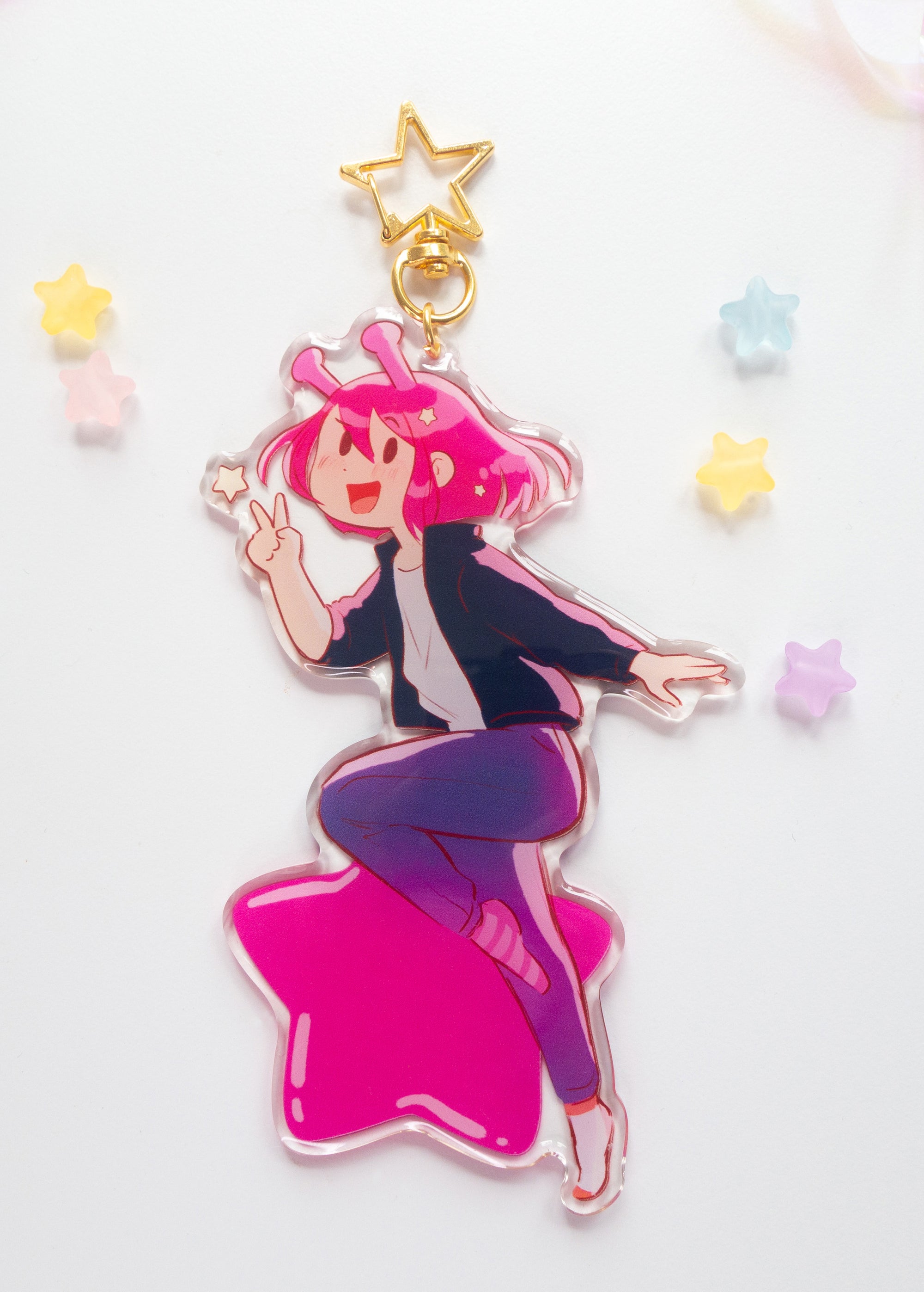 Colorful ADHD Alien acrylic charm with pink hair and a star on a white background