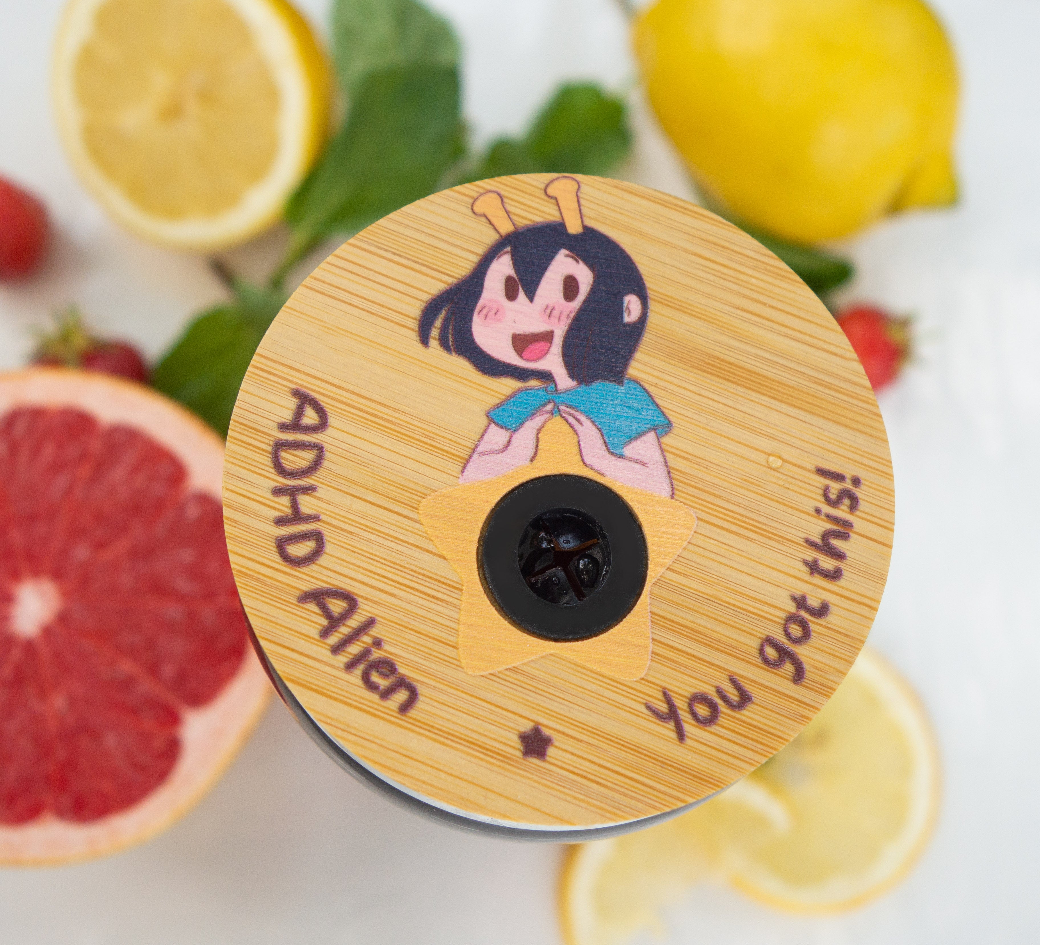 Bamboo tumbler lid with ADHD Alien cartoon character and text 'ADHD Alien You Got This!' surrounded by fruits.