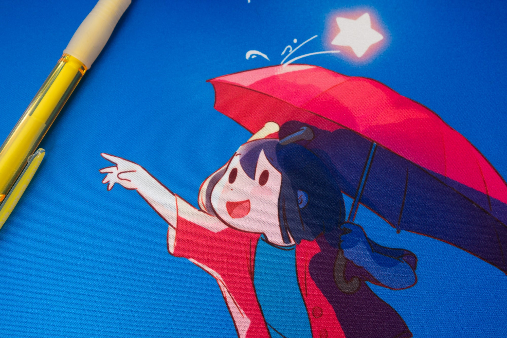 Illustration of the ADHD Alien character with a red umbrella against a blue background, with a pen on the side.