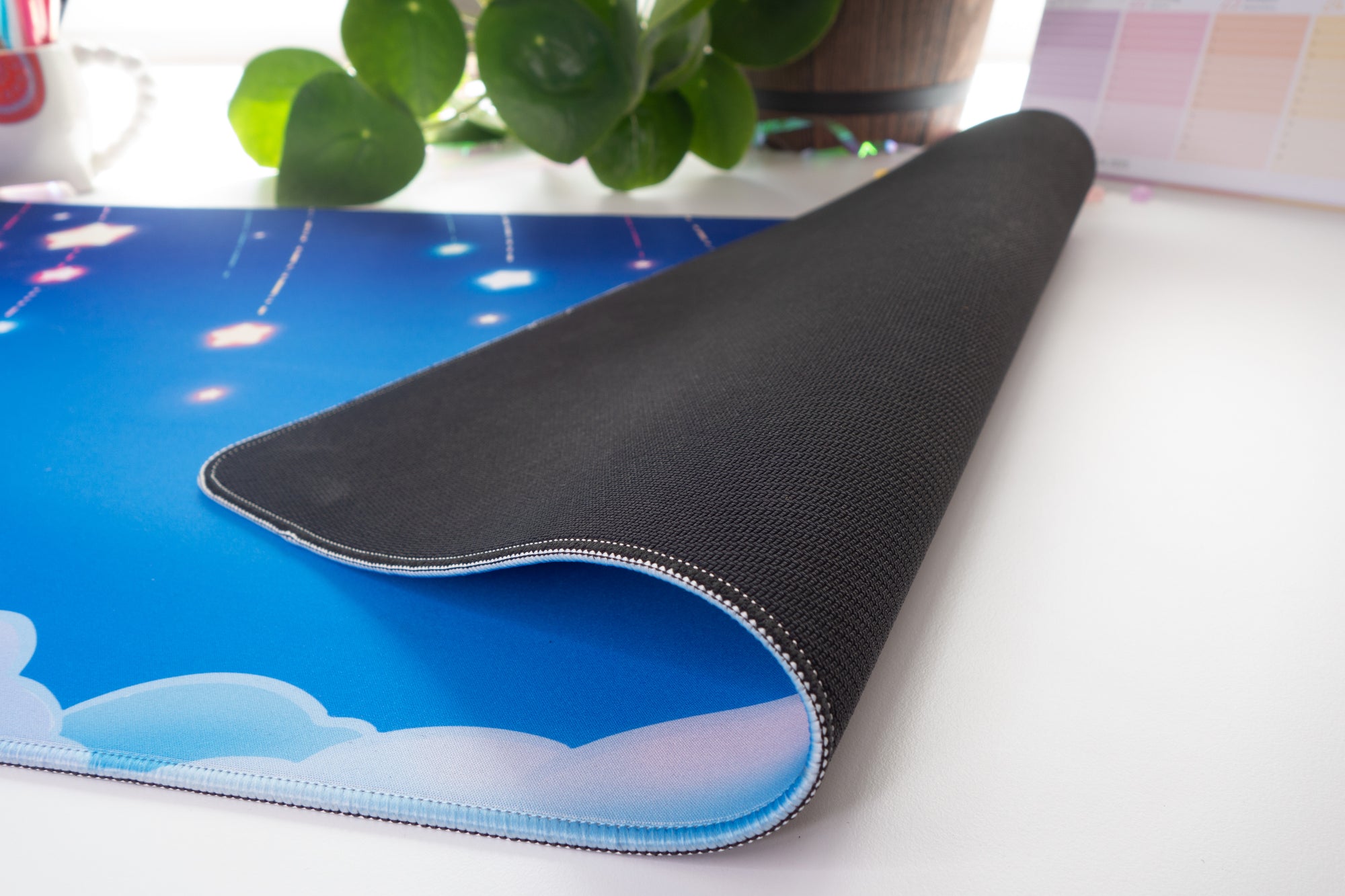 Desk mat folded over to reveal the rubber backside on a white background