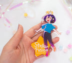 Hand holding the acrylic charm with 'Stellar Fusion' text on the star part over a white background