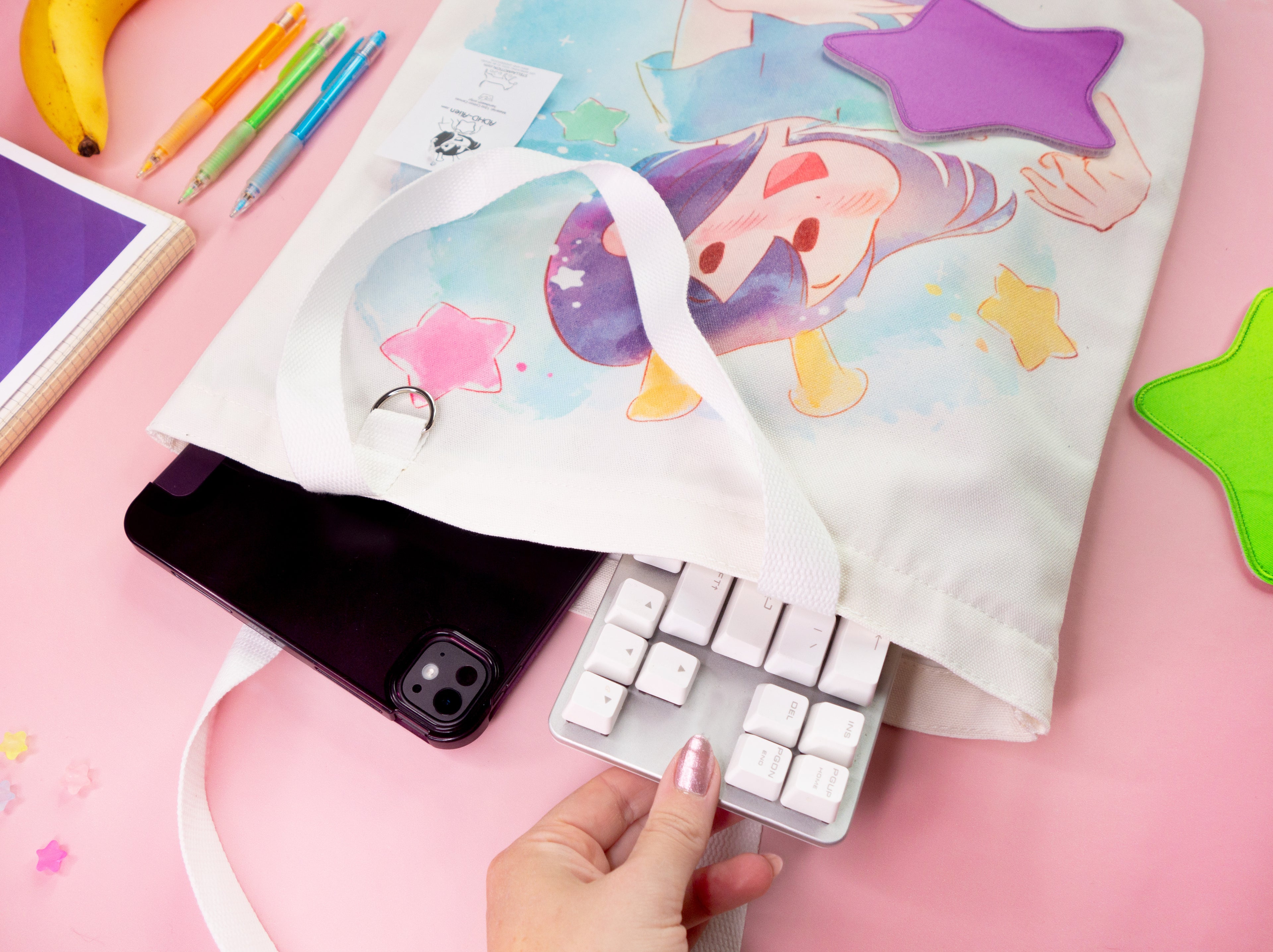 Hand taking objects like an ipad and a keyboard out of the totebag