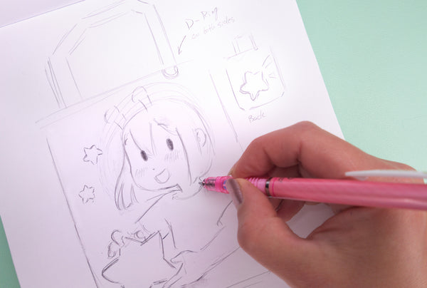 Hand sketching the ADHD Alien character on a notebook with a pink pen. - Making of image 1
