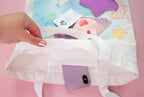 Hand holding the totebag open to reveal an inside pocket